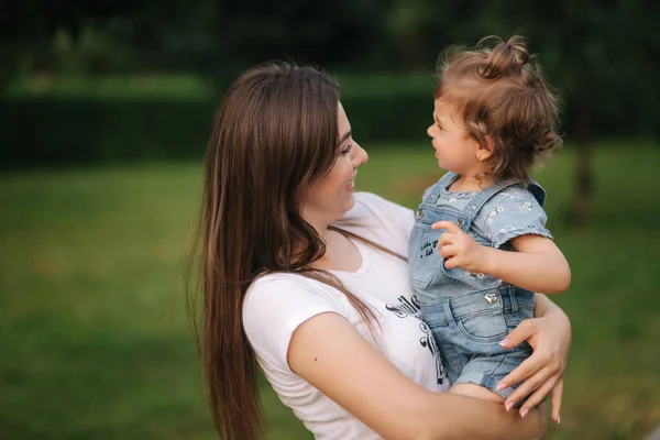 Portrait of beautiful mom with adorable little girl. Happy family outdoors. Daughter look at mom — Stock Photo, Image