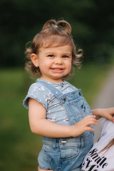 Mooi dochtertje van achttien maanden oud aan moeders handen. Schattig meisje glimlach — Stockfoto