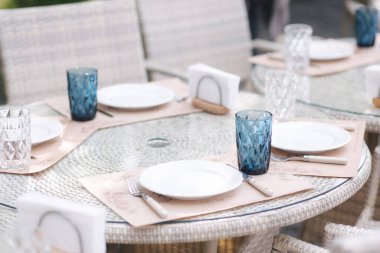 Yaz terasında servis masası hazır. Kafede çatal bıçak takımı. Yeşil arkaplan