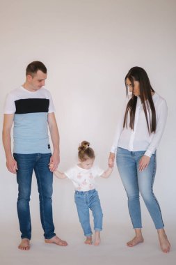 Genç aile stüdyoda. Anne, baba ve küçük kızının fotoşopları var.