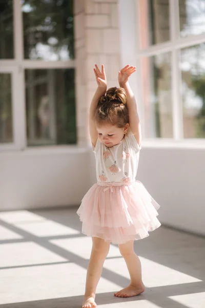 Leuk klein meisje van drie in jurk poserend voor fotografe in studio. Beutiful kleine meisje dans — Stockfoto