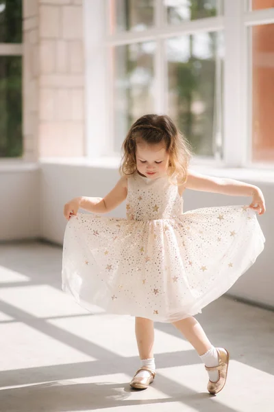 Χαριτωμένο κοριτσάκι τριών ετών με φόρεμα που ποζάρει για φωτογράφο στο στούντιο. Όμορφος κοριτσίστικος χορός — Φωτογραφία Αρχείου