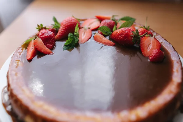 Torta de morango saborosa decorada com folhas de hortelã na mesa de madeira. Esmalte de caramelo em cima da torta. Pequeno-almoço Vegan. Lactose e sem glúten — Fotografia de Stock