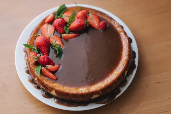 Torta de morango saborosa decorada com folhas de hortelã na mesa de madeira. Esmalte de caramelo em cima da torta. Pequeno-almoço Vegan. Lactose e sem glúten — Fotografia de Stock