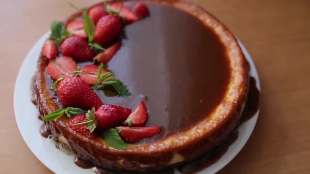 Torta de morango saborosa decorada com folhas de hortelã na mesa de madeira. Esmalte de caramelo em cima da torta. Pequeno-almoço Vegan. Lactose e sem glúten — Vídeo de Stock