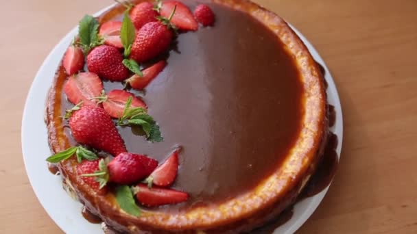 Torta de morango deliciosa decorada com folhas de hortelã na mesa de madeira. Esmalte de caramelo em cima da torta. Pequeno-almoço Vegan. Lactose e sem glúten — Vídeo de Stock