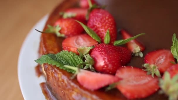 Torta de morango saborosa decorada com folhas de hortelã na mesa de madeira. Esmalte de caramelo em cima da torta. Pequeno-almoço Vegan. Lactose e sem glúten — Vídeo de Stock