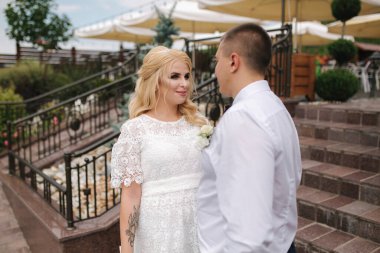 Beyaz elbiseli güzel bir çift dışarıda yürüyor. Restoran