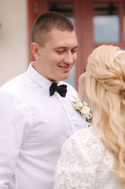 Dışarıda yürüyen mutlu yeni evliler. Sarı saçlı kadın ve beyaz gömlekli genç adam.