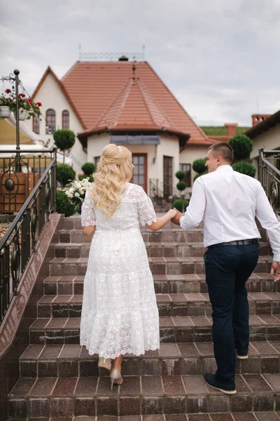 Όμορφο ζευγάρι σε λευκό περπάτημα σε εξωτερικούς χώρους. Εστιατόριο — Φωτογραφία Αρχείου