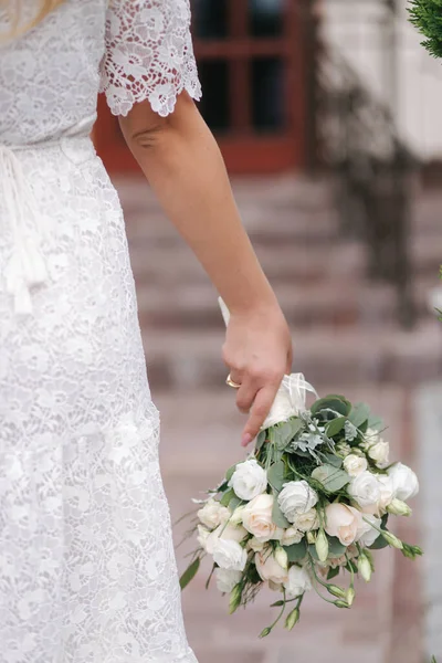 Жінка тримає в руках букет з білих троянд. Міні весілля. Блондинка наречена з букетом квітів — стокове фото