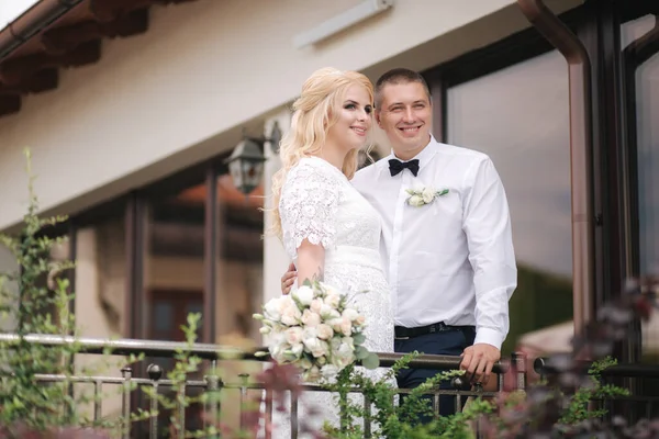 Heureux jeunes mariés marchant à l'extérieur. Femme aux cheveux blonds et jeune homme en chemise blanche — Photo