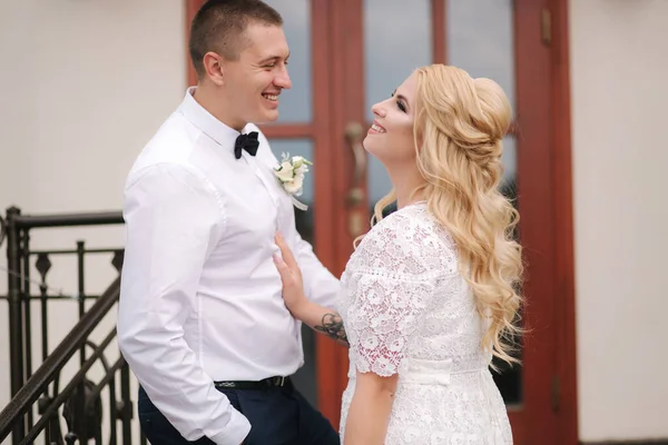 Felizes recém-casados a andar ao ar livre. Mulher de cabelo loiro e jovem de camisa branca — Fotografia de Stock