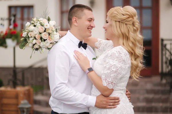 Glada nygifta som går utomhus. Blond hår kvinna och ung man i vit skjorta — Stockfoto
