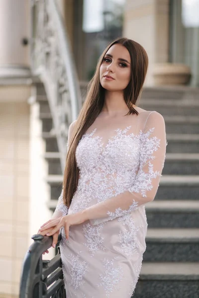 Приваблива молода жінка в красивій сукні стоїть на сходах — стокове фото