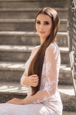 Akşamları fotoğrafçıya poz veren güzel genç mankenler. Merdivenlerde oturan manken.