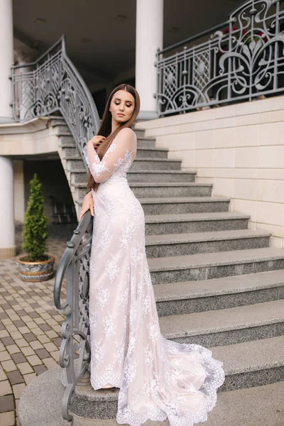 웨딩 드레스를 입고 큰 레스토랑 옆 계단에 서 있는 멋진 모델 — 스톡 사진