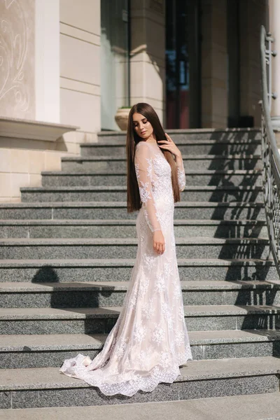 Prachtig model in trouwjurk staan op trap door groot restaurant — Stockfoto
