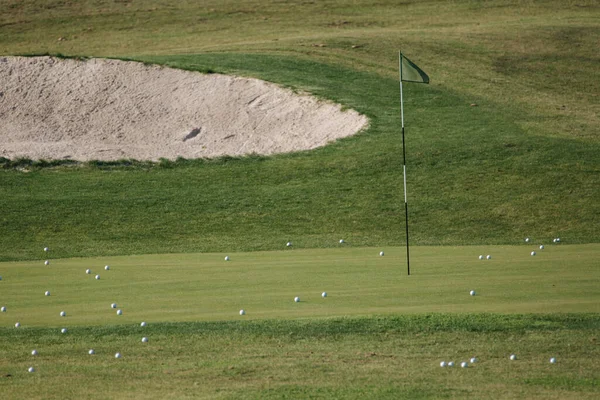 Krásný green field golf a spousta golfových míčků na trávě — Stock fotografie