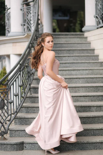 Hermosa chica con el pelo rizado en pie vestido de noche en las escaleras — Foto de Stock