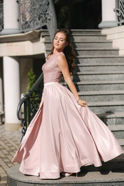 Hermosa chica con el pelo rizado en pie vestido de noche en las escaleras — Foto de Stock