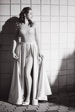 Fotoğrafçıya poz veren güzel genç bir model. Kıvırcık saçlı ve makyajlı kadın.