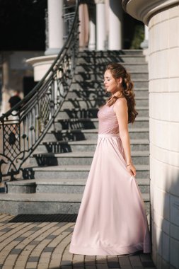 Fotoğrafçıya poz veren güzel genç bir model. Kıvırcık saçlı ve makyajlı kadın.