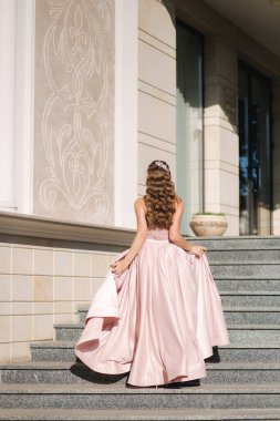 Fotoğrafçıya poz veren güzel genç bir model. Kıvırcık saçlı ve makyajlı kadın.