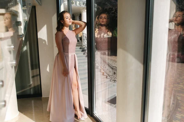 Елегантна молода жінка стоїть біля великого вікна в розкішному ресторані — стокове фото