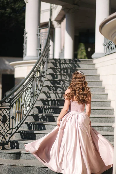 Zarif elbiseli kadının arka görünüşü merdivenlerden yukarı çıkıyor. — Stok fotoğraf