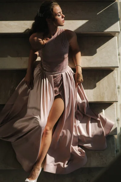 Muhteşem elbiseli zarif bir kadın lüks bir restoranın merdivenlerinde yatıyor. — Stok fotoğraf