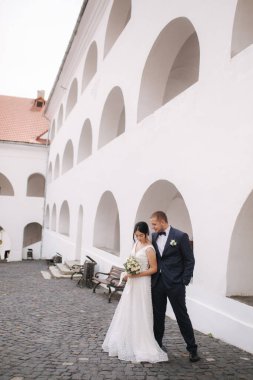 Mutlu evlilik çifti güzel Plece 'ler içinde yürüyor. Damat, sevgili karısına sarıl.