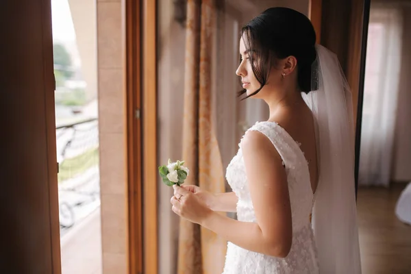 O primeiro olhar do noivo e da noiva na casa das noivas. Tender bride Fique perto da janela e aguarde o noivo — Fotografia de Stock