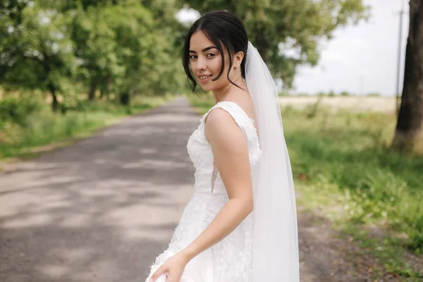 Elegante noiva caminhar no parque e girar arround. Noiva feliz, dia do casamento — Fotografia de Stock