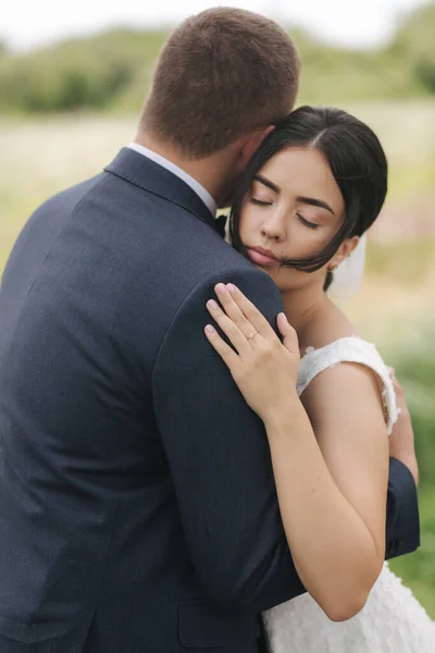 Recém-casados a caminhar no parque no dia do casamento. Bela noiva e belo noivo — Fotografia de Stock