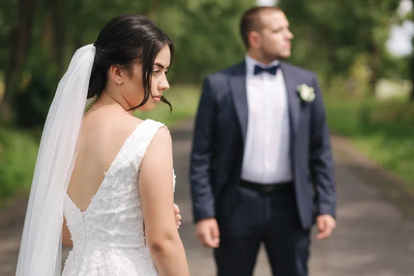 Yeni evliler düğün günü parkta yürürler. Güzel gelin ve yakışıklı damat — Stok fotoğraf