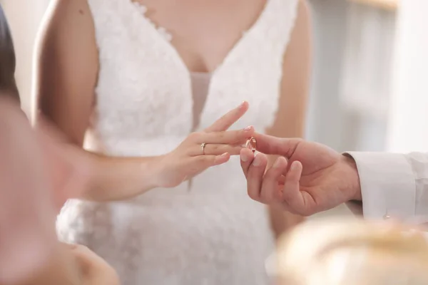 Крупный план жениха и невесты надели кольца на палец в церкви — стоковое фото
