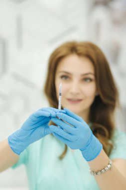 Kozmetikçi şırıngayı elinde tutuyor. Enjeksiyon. Klinik