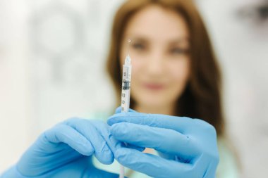 Kozmetikçi şırıngayı elinde tutuyor. Enjeksiyon. Klinik