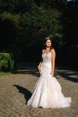 Parkta yürüyen güzel gelinlikli çekici genç gelin modeli.