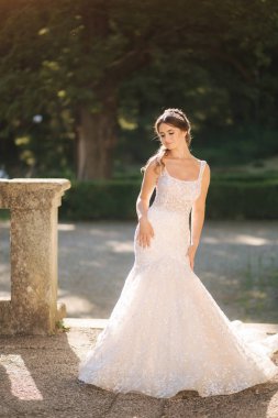 Parkta yürüyen güzel gelinlikli çekici genç gelin modeli.