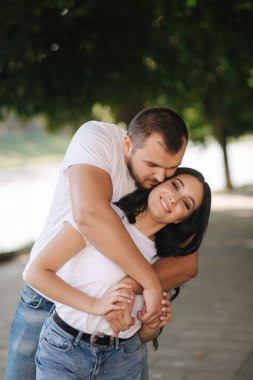Muhteşem kız arkadaşı olan yakışıklı bir adam. Mutlu çift embabkment boyunca yürüyor. Yeşil arkaplan