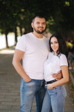 Muhteşem kız arkadaşı olan yakışıklı bir adam. Mutlu çift embabkment boyunca yürüyor. Yeşil arkaplan