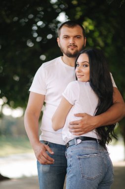 Muhteşem kız arkadaşı olan yakışıklı bir adam. Mutlu çift embabkment boyunca yürüyor. Yeşil arkaplan