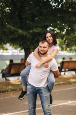 Güzel Gilr erkek arkadaşının sırtına bindi ve ona sarıldı. Mutlu gülümseyen çift şehirde vakit geçiriyor.