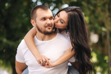 Güzel Gilr erkek arkadaşının sırtına bindi ve ona sarıldı. Mutlu gülümseyen çift şehirde vakit geçiriyor.