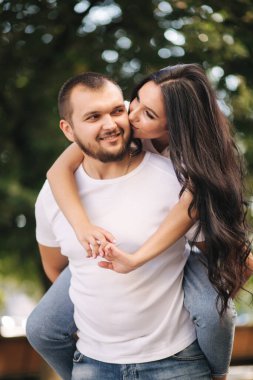 Güzel Gilr erkek arkadaşının sırtına bindi ve ona sarıldı. Mutlu gülümseyen çift şehirde vakit geçiriyor.