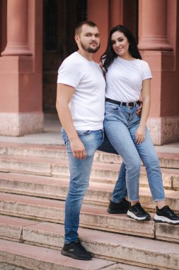 Şehirde yürüyen iki belallı insan. Kot ve beyaz tişörtlü güzel çift iyi eğlenceler.