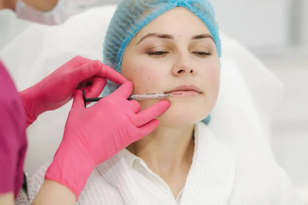 Lip augmentation. Woman getting beauty injection for lips in beauty salon