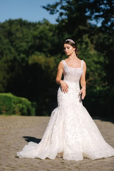 Vonzó fiatal menyasszony modell gyönyörű esküvői ruha séta a parkban — Stock Fotó